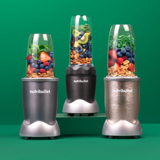 Trio of nutribullet blenders on green background.