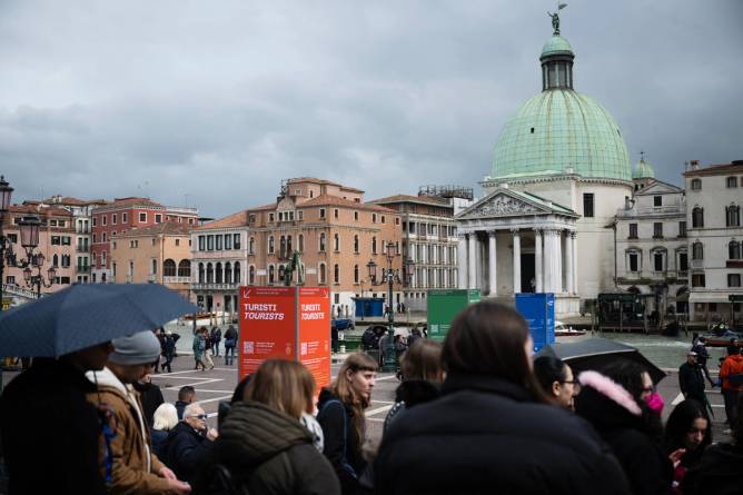 Tousist stand near Santa Lucia train station on April 24, 2024 in Venice on the eve of the start of the official trial of the city’s booking system for day-trippers