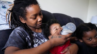 Ashley Yancey feeds her 11 month-old daughter Olivia as two-year old Oliver Tolvert looks on at right, Douglasville, Ga., Dec. 14, 2023.