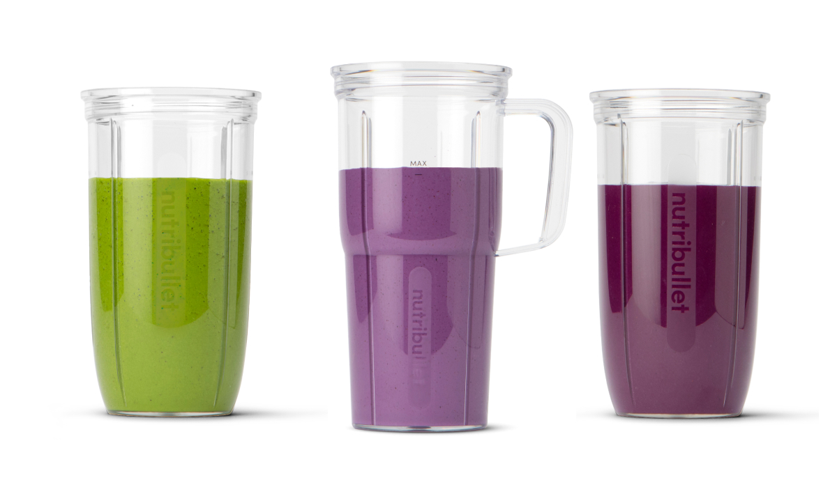 Three blending cups filled with colored juices