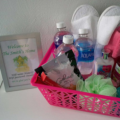 Blog idea: pink guest basket filled with water bottles, lotion, candy, slippers, and more 