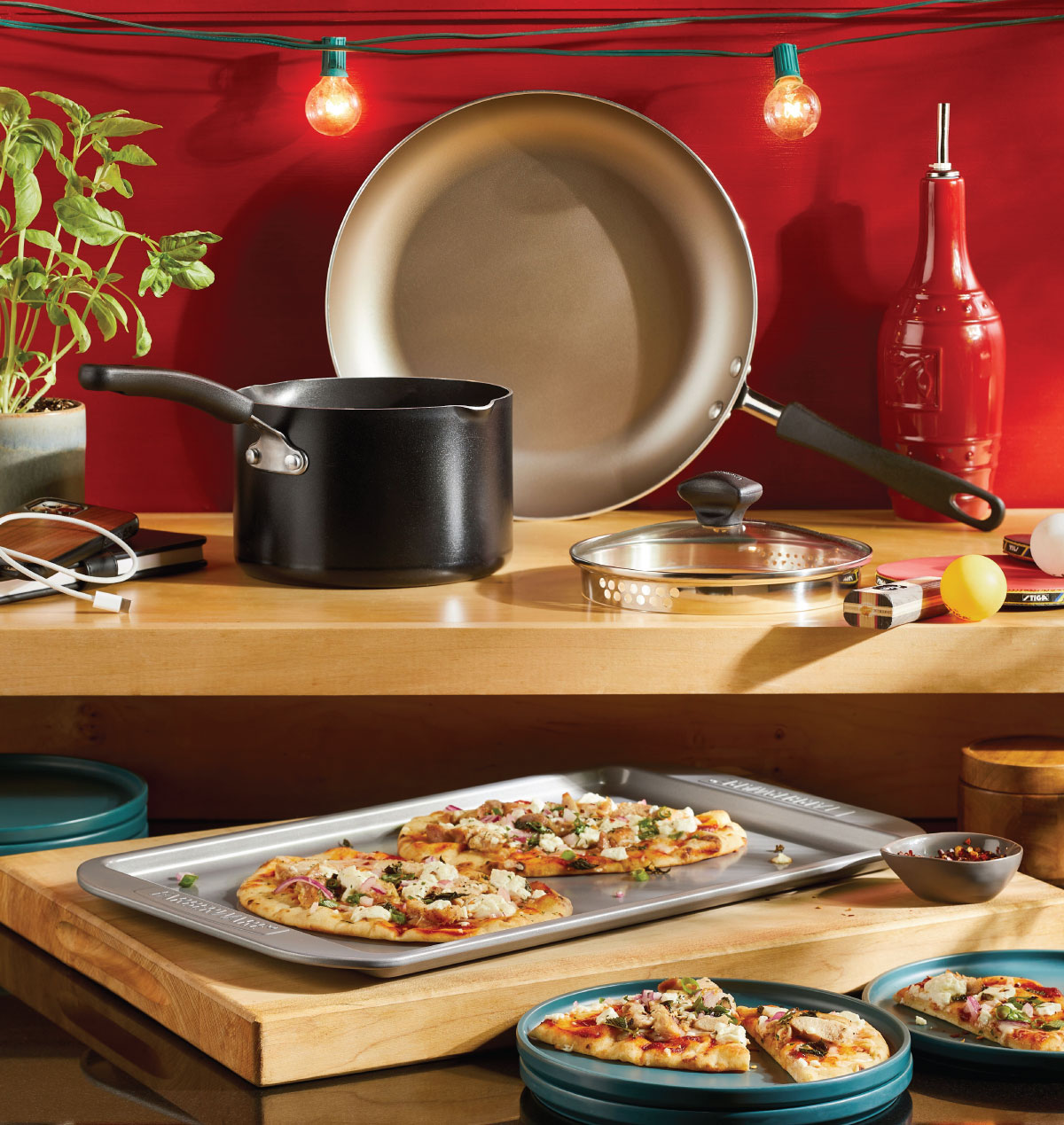 Image: assorted pots and pans on a kitchen counter with flatbread on a baking sheet.