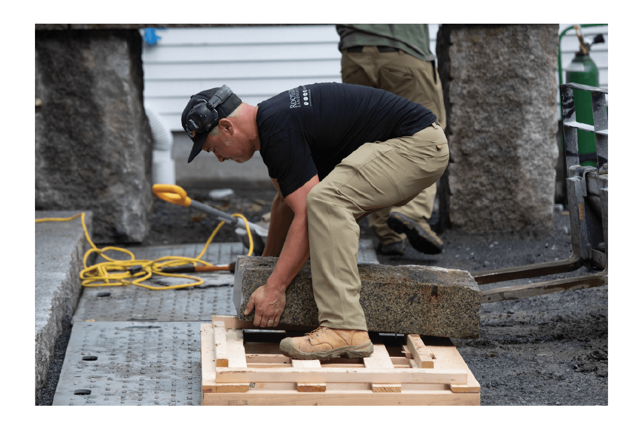 Stone worker lifting piece of marble in The Shop Pant in khaki