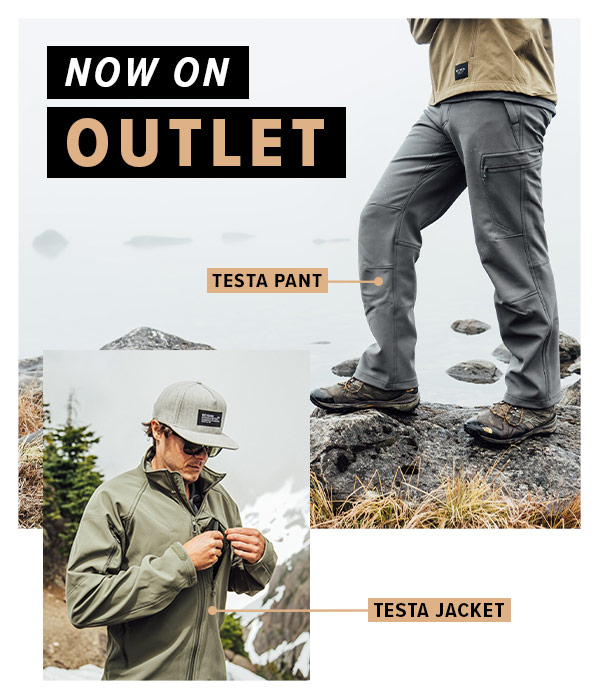 Man wearing the Testa Softshell pant in grey and the Testa Softshell jacket in green in front of a rocky mountain lake.Text Overlay saying "Now on Outlet"