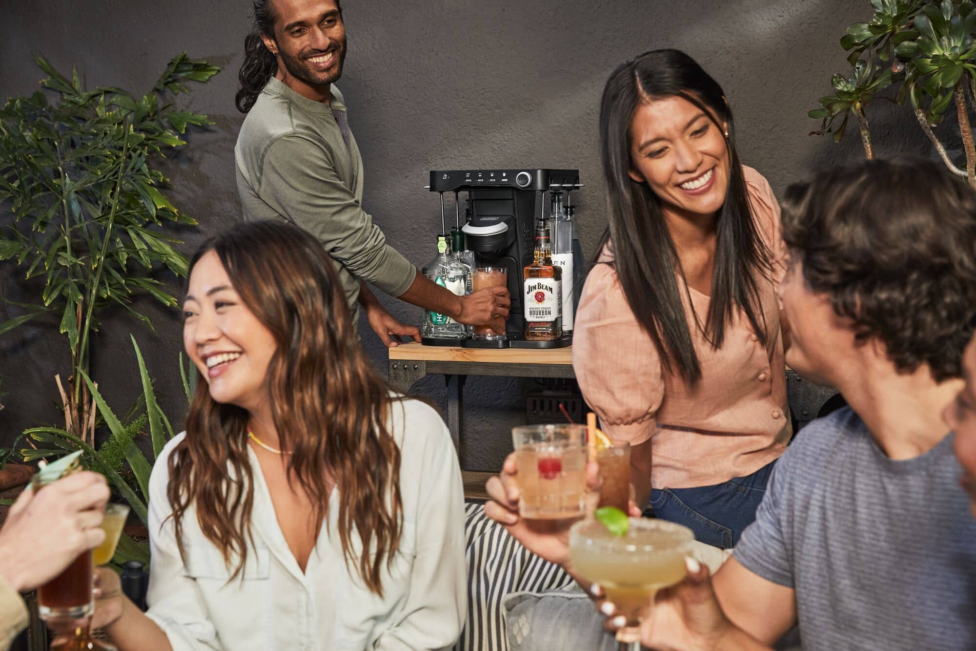 people enjoying cocktails with bev cocktail maker in background