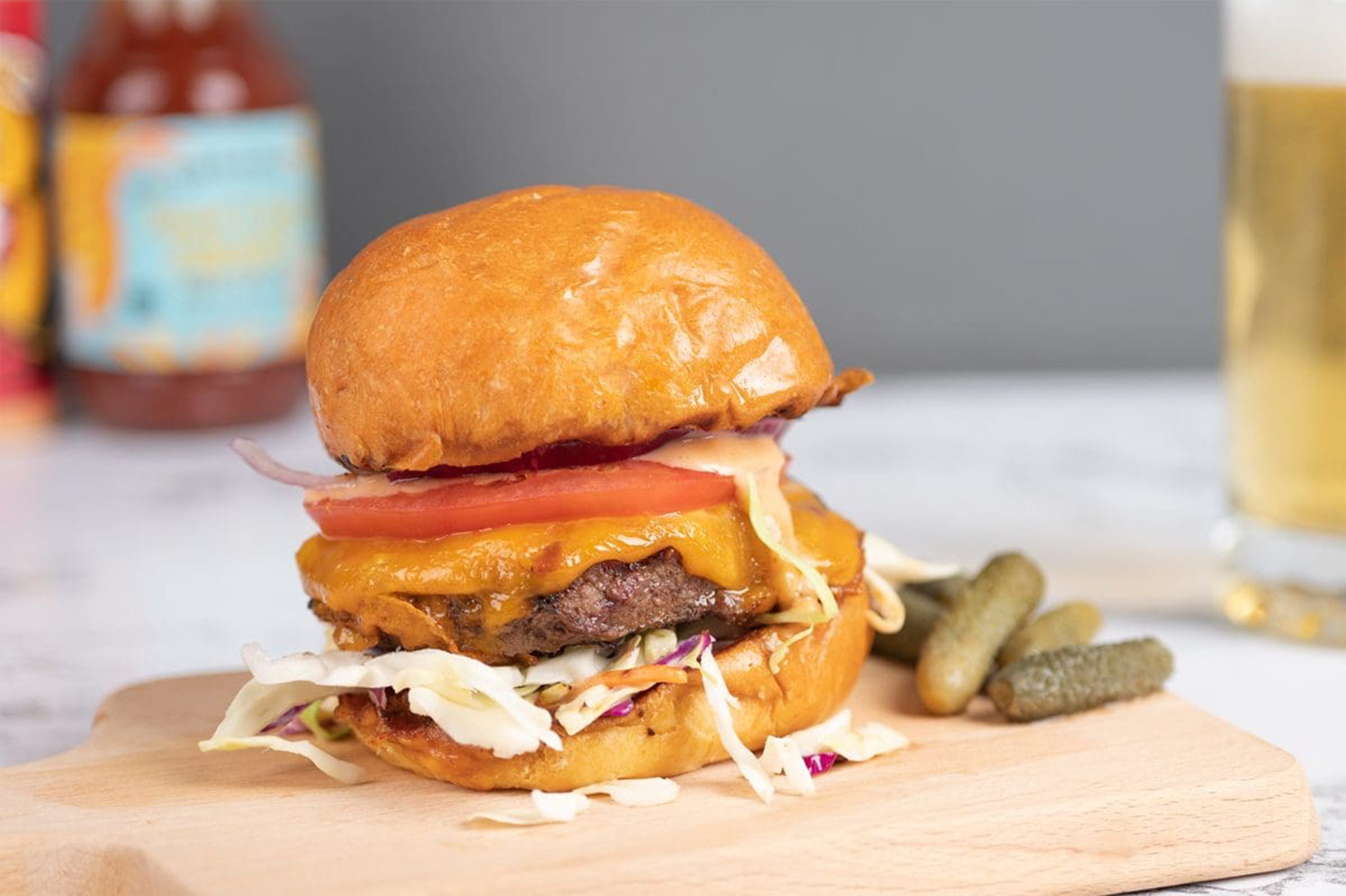 a mouth-watering cheeseburger on a wooden cutting board with pickles