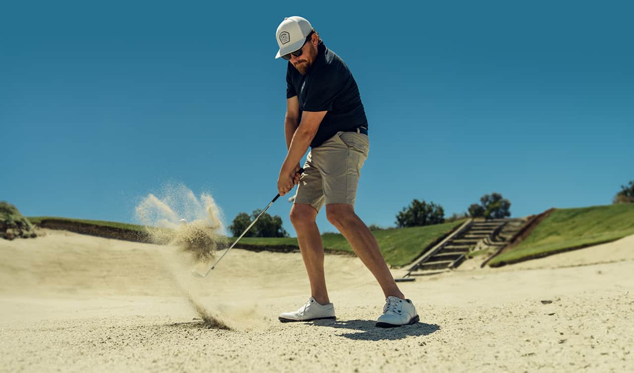 golfer hitting ball out of a bunker