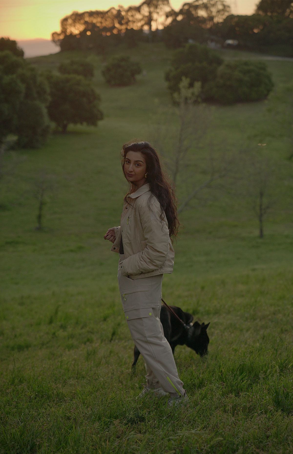 Aditi Mayer walking her dog in a grassy field