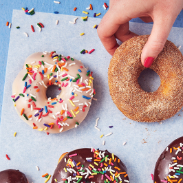 air-fried donuts, one with pink frosting and rainbow sprinkles and the other covered in cinnamon sugar