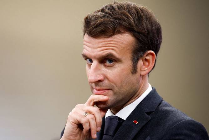 French President Emmanuel Macron looks on as he visits Chanel's Metiers d'Art workshops at le 19M