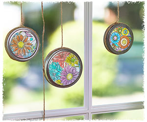 Flower coloring page suncatchers hanging in a mason jar lid in front of a sunny window