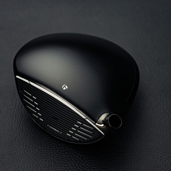 Club Face of the Qi10 max Black Out driver on a black leather background