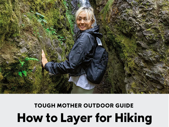 A woman hiking through a mossy, rocky landscape.