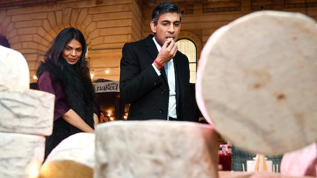 U.K. Prime Minister Rishi Sunak samples a cheese next to his wife Akshata Murty at a market in London, Nov. 30, 2022.