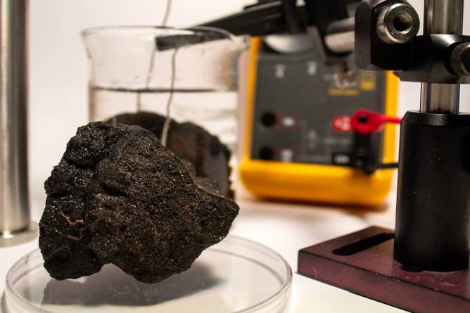 Polymetallic nodules, collected from the ocean floor, sit in simulated seawater in chemist Franz Geiger’s laboratory at Northwestern University. Platinum electrodes measure the nodules voltages.