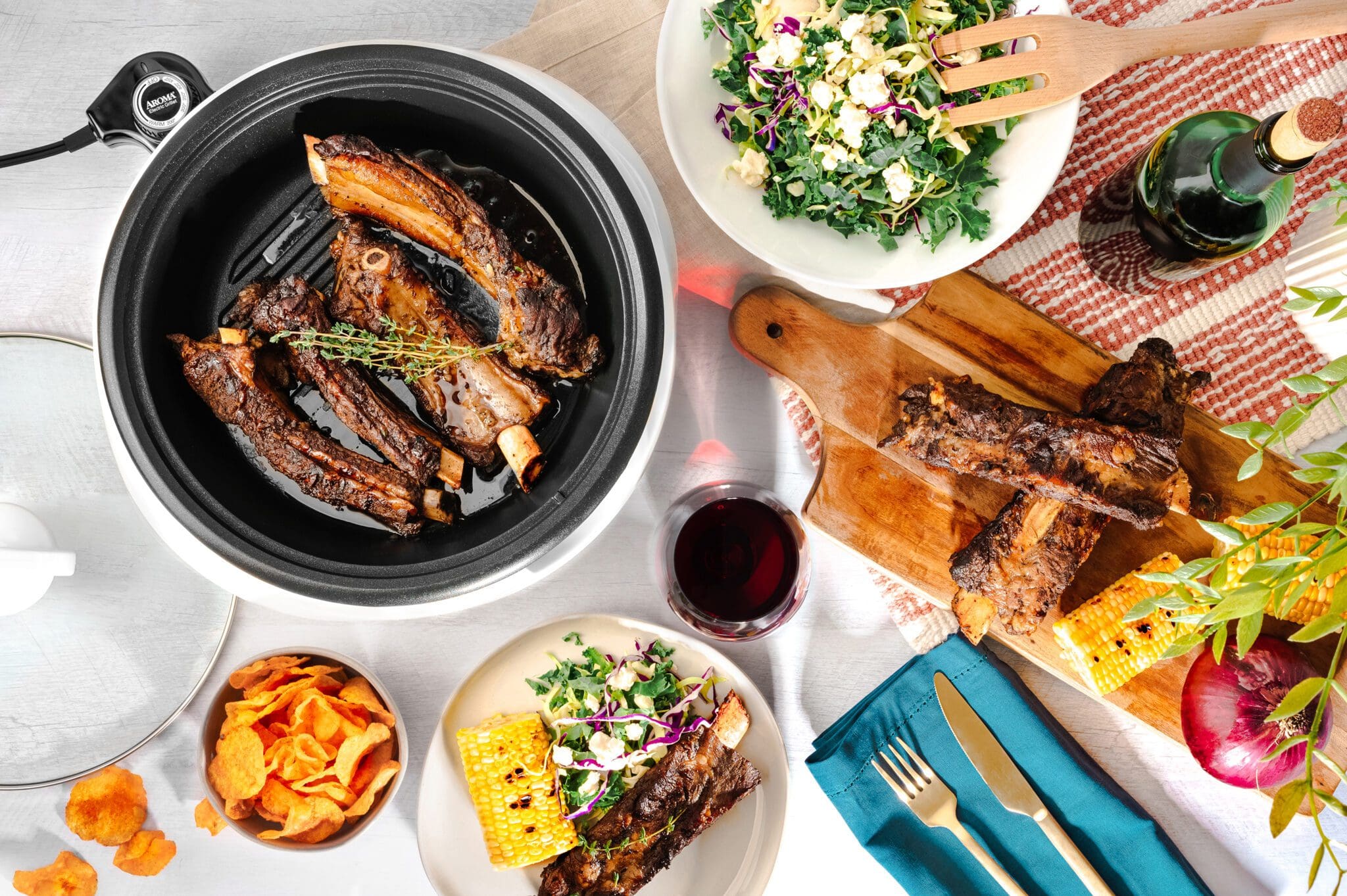 top-down view of tender beef ribs in Aroma Grillet with barbecue corn and sides