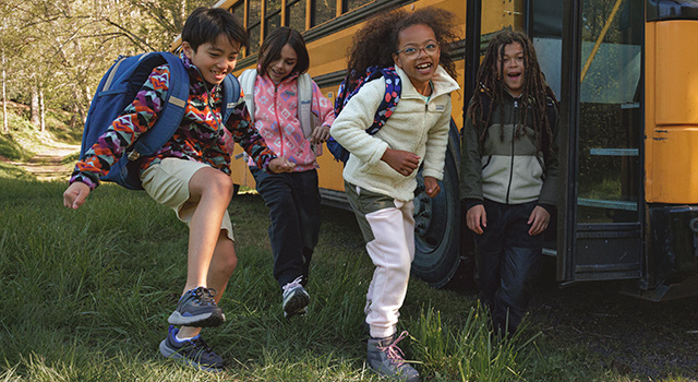 Group of kids with Columbia backpacks and gear. 