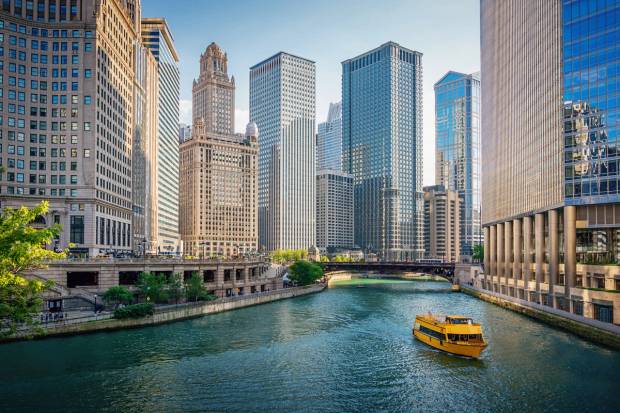 Downtown Chicago Skyscraper Cityscape along the Chicago River. Typical yellow Tourboat cruising on the Chicago River