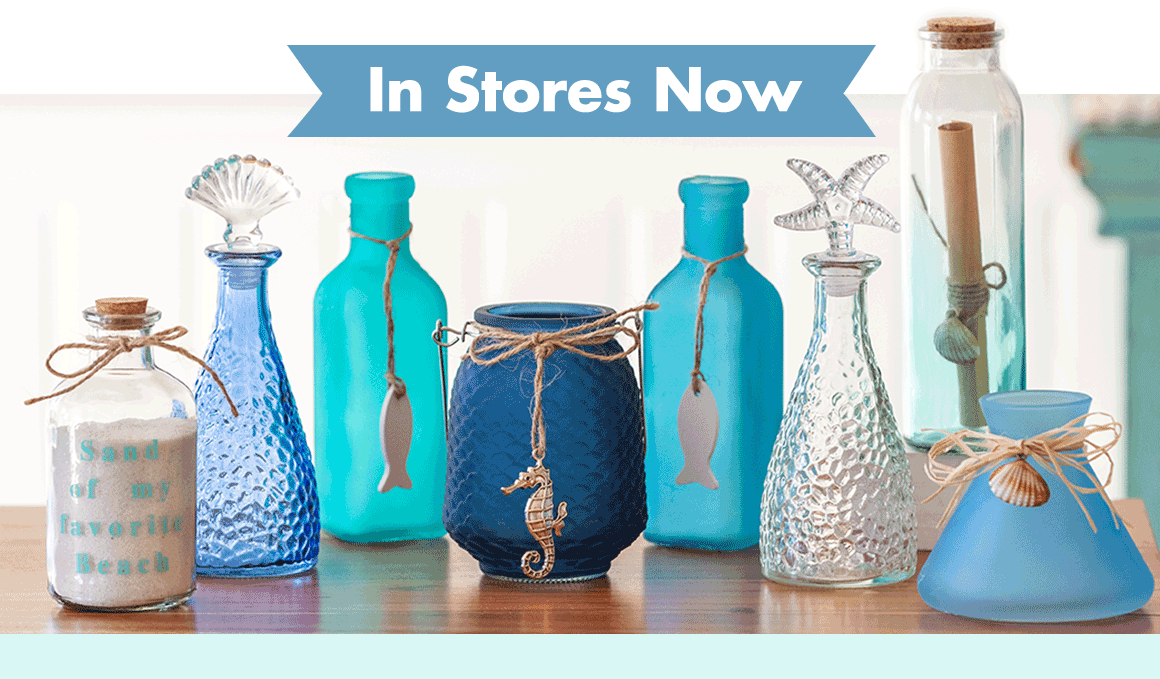 Variety of blue and clear decorative glass vases with coastal charms on a table