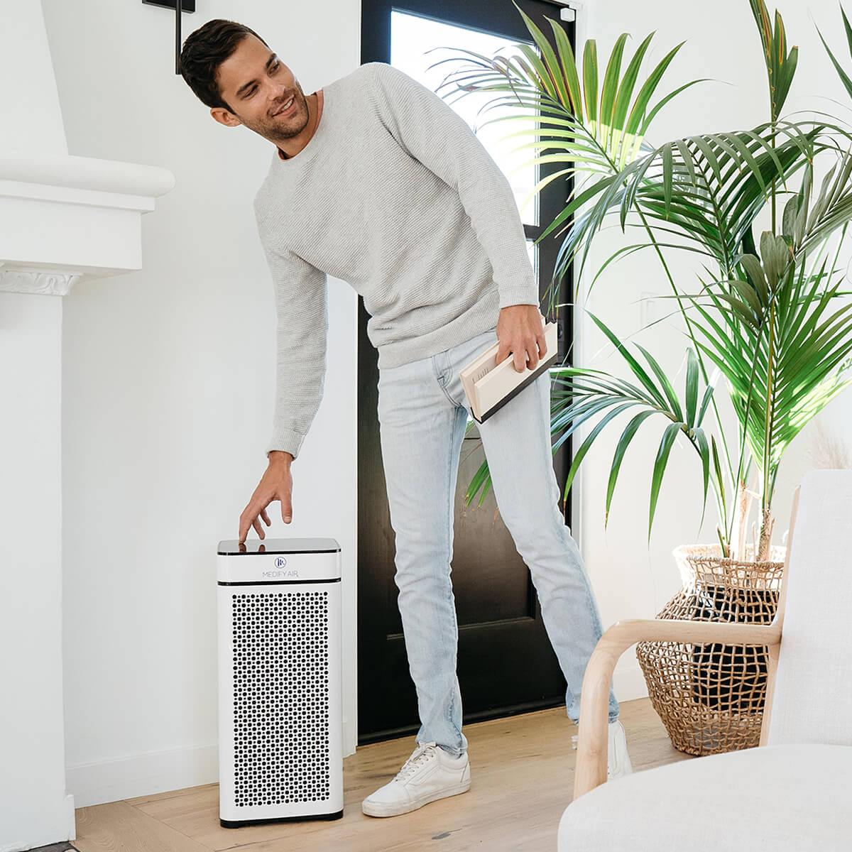 Female in bedroom next to a black MA-14 air purifier