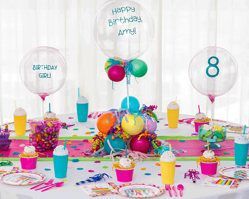 Blog idea: a birthday tablescape featuring 3 pink bubble balloons and colorful latex balloons, cupcakes, confetti, streamers, and more