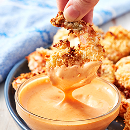 air fryer shrimp being dipped into sauce