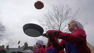 Schoolchildren take part in the children's races prior to the annual Pancake race, Olney,, England, Feb. 13, 2024.