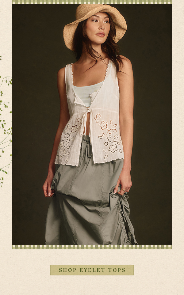 Woman wearing eyelet top. Shop tops.