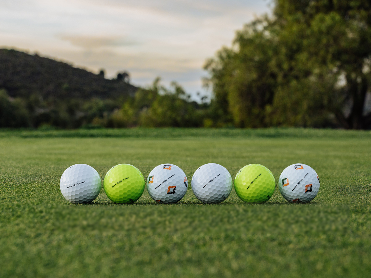 2024 TP5 and TP5x golf ball family-white, yellow and pix lined up on the green outside.