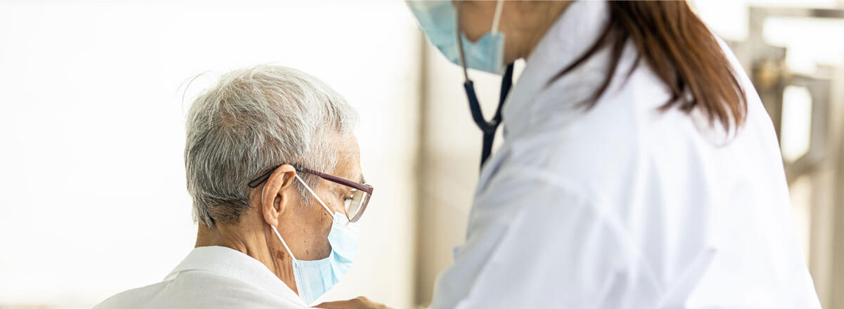 Senior citizen getting medical assistance while wearing a mask