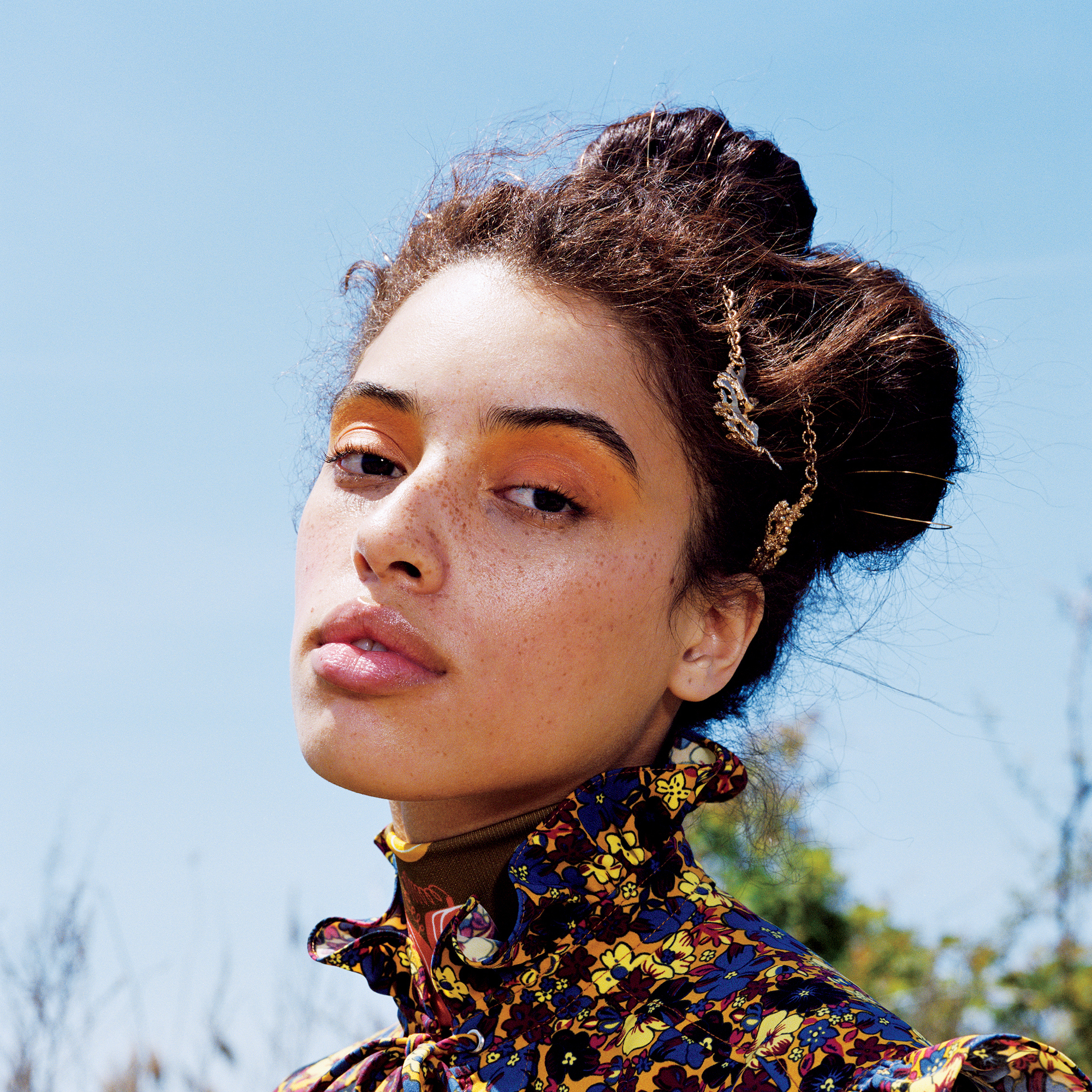 Model outside wearing a neck high floral top