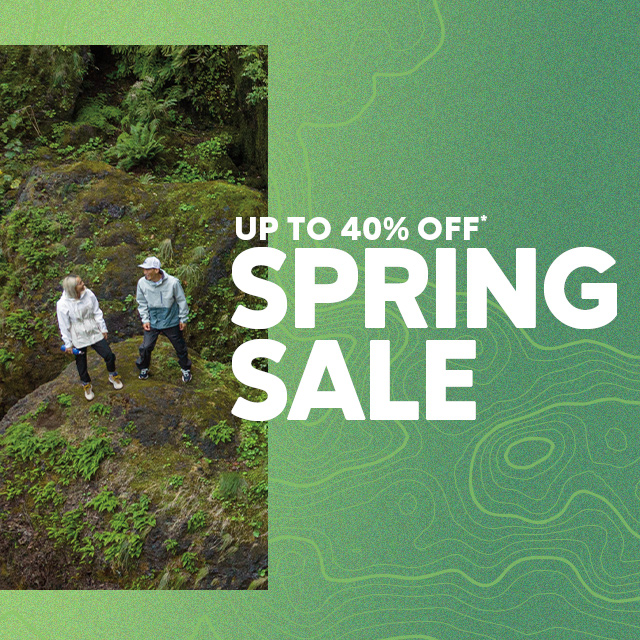 UP TO 40% OFF SPRING SALE overlaying an image of two people hiking near a mossy waterfall.