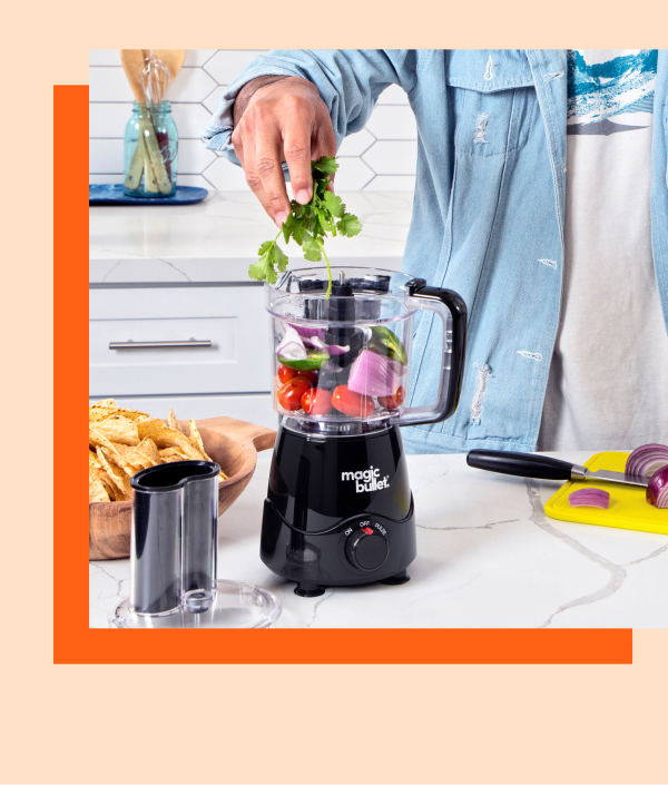 Hands placing cilantro in magic bullet Kitchen Prep.