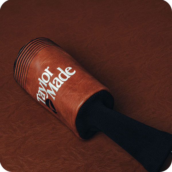 Copper BRNR Mini Driver Headcover laying down on a brown leather background