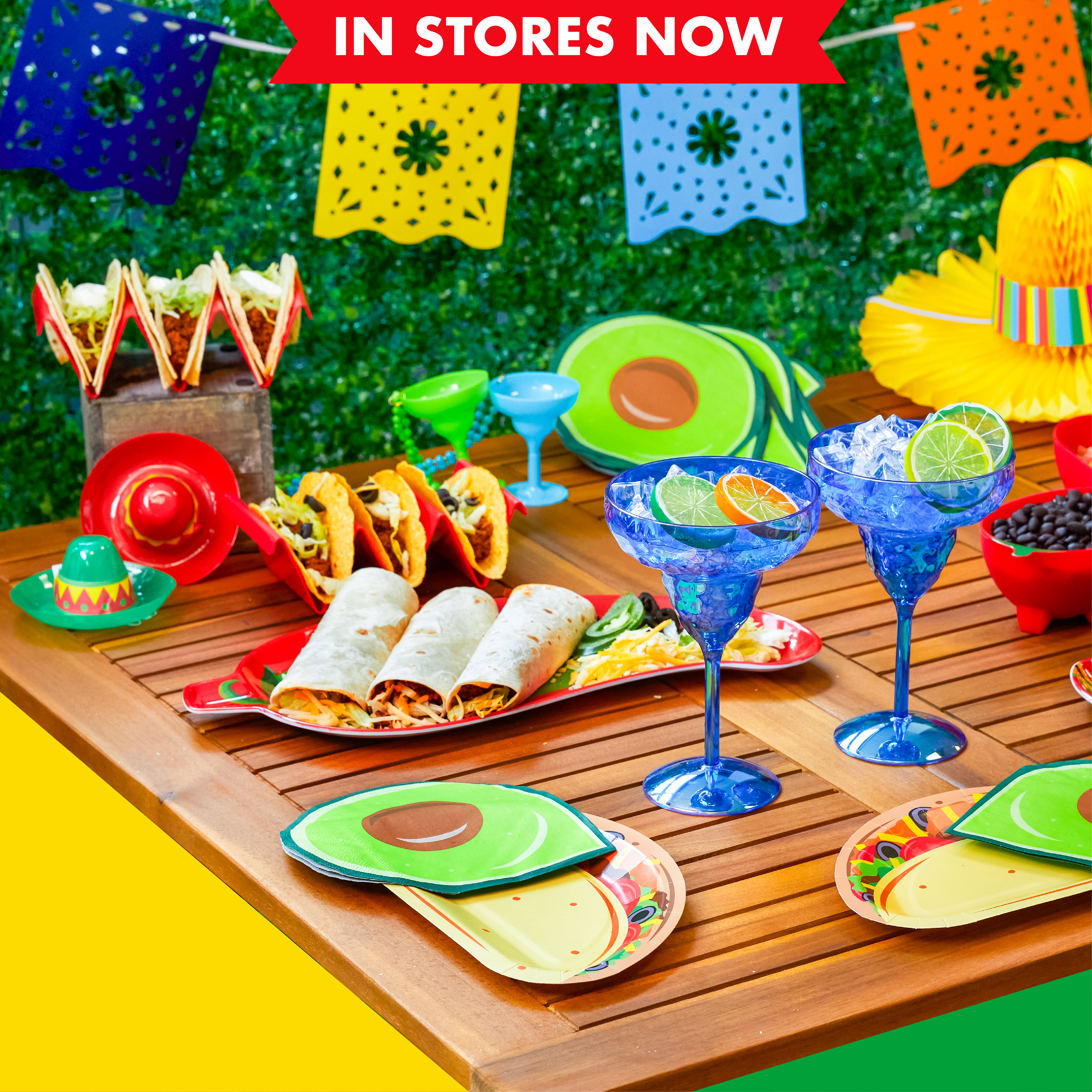 Table of Cindo de Mayo party decorations, plates with tacos, margarita glasses, and more