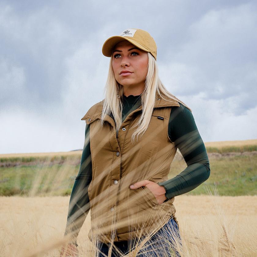 Woman in a field wearing Duckworth vest