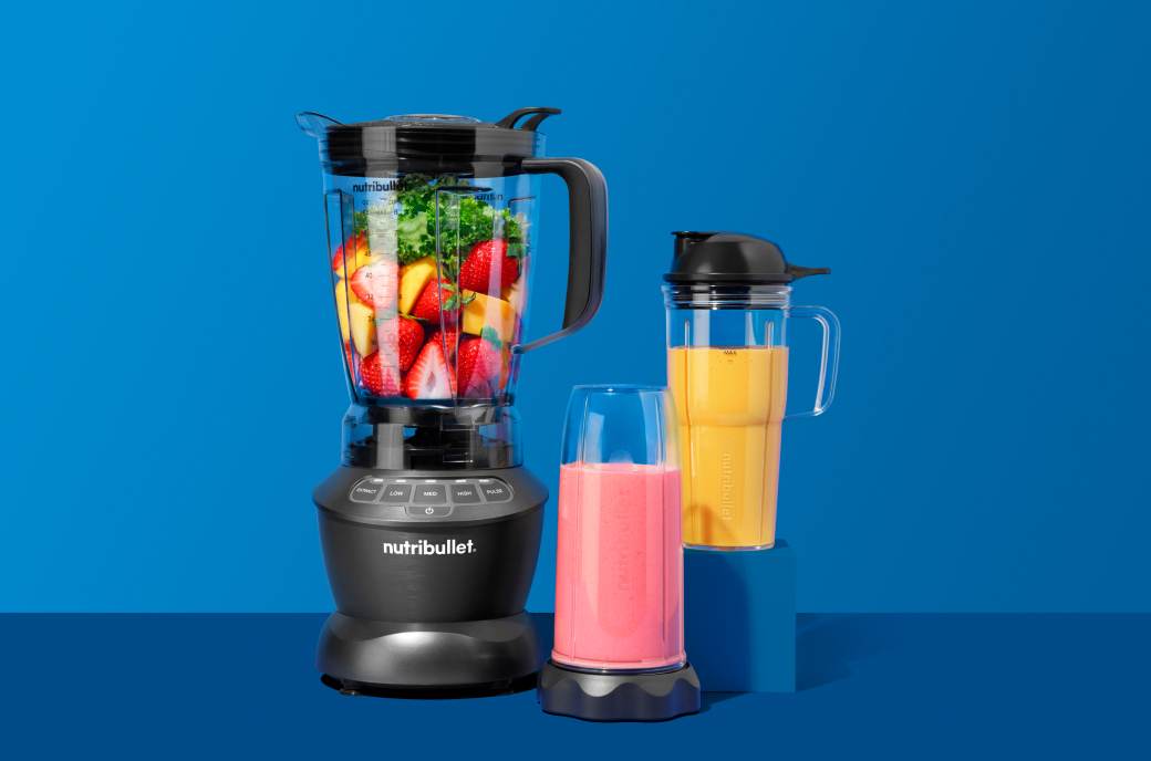 nutribullet Blender Combo filled with fruits and vegetables, next to cups filled with frozen drinks