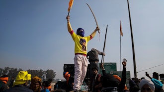 A protester carrying a ceremonial sword shouts slogans as farmers face police near Shambhu, India, Feb.16, 2024.