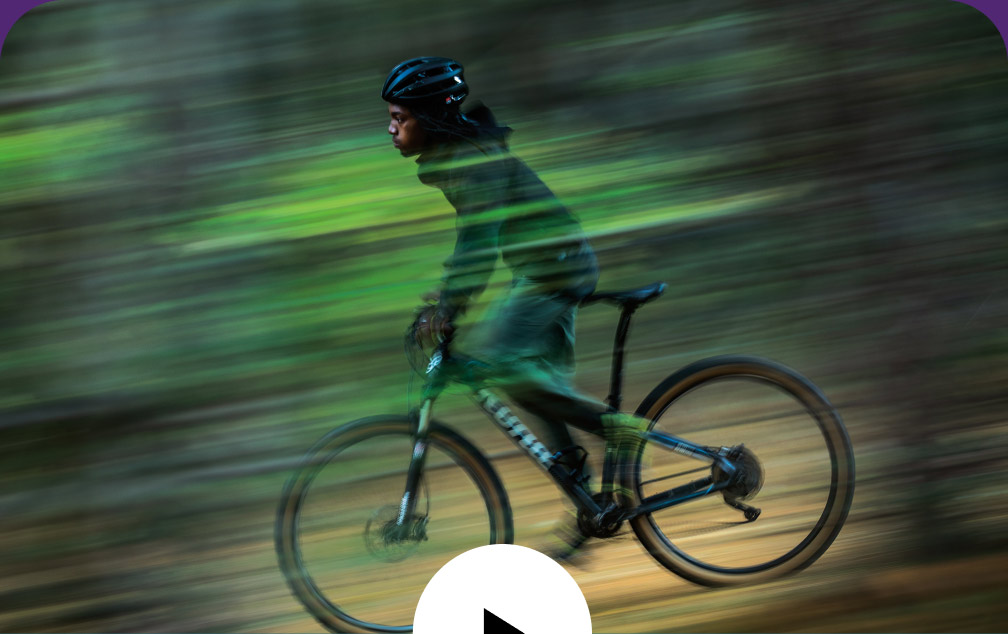 A mountain biker speeds through the forest.