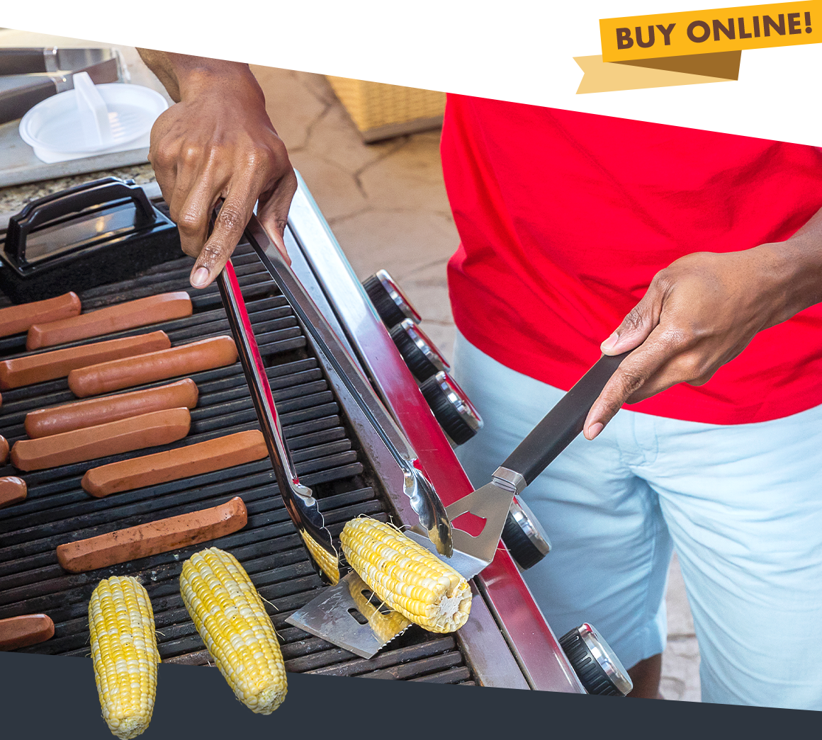 A man cooking hot dogs and corn on a grill