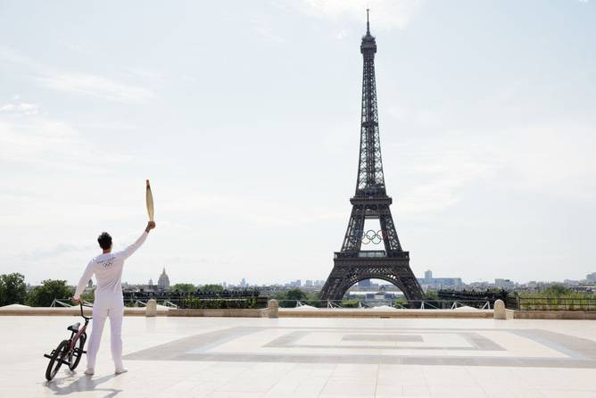 Torch bearer Matthias Dandois, French Bicycle rider, poses for a photo with the Olympic Torch at Place du Trocadero with the Eiffel Tower in view