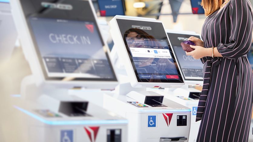 A Delta customer checks in at a kiosk using an American Express credit card