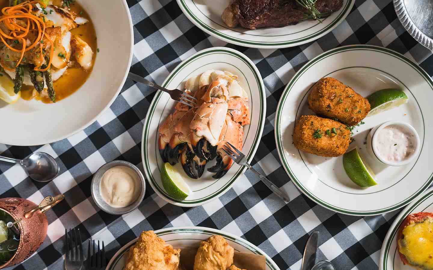 A table featuring dishes of stone crabs and accompaniments at Joe's Stone Crab