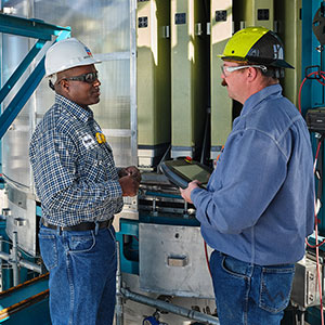 two chevron employees with hard hats and goggles discussing the outcome of the pipeline