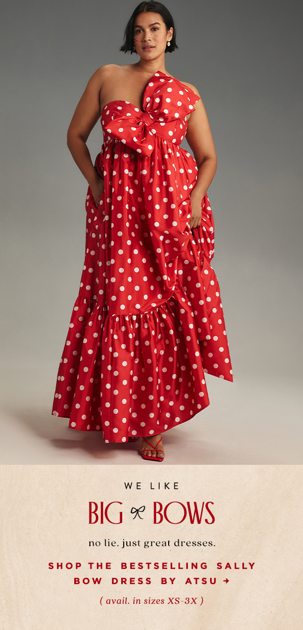 Woman wearing red and white polka dot dress. Shop Shop the Sally bow dress.