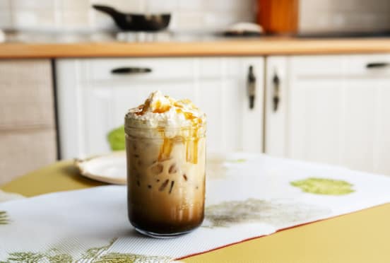 Iced coffee with whipped cream in a kitchen