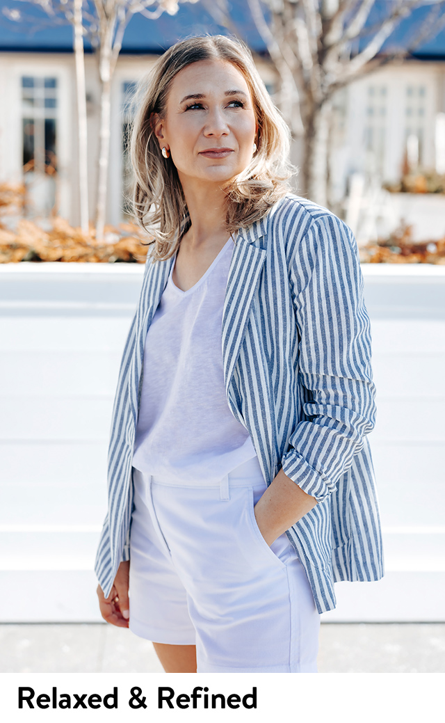 A woman wearing a striped blazer, T-shirt & white shorts.