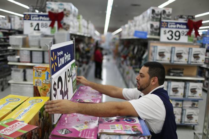 Walmart employee adjusts a sign