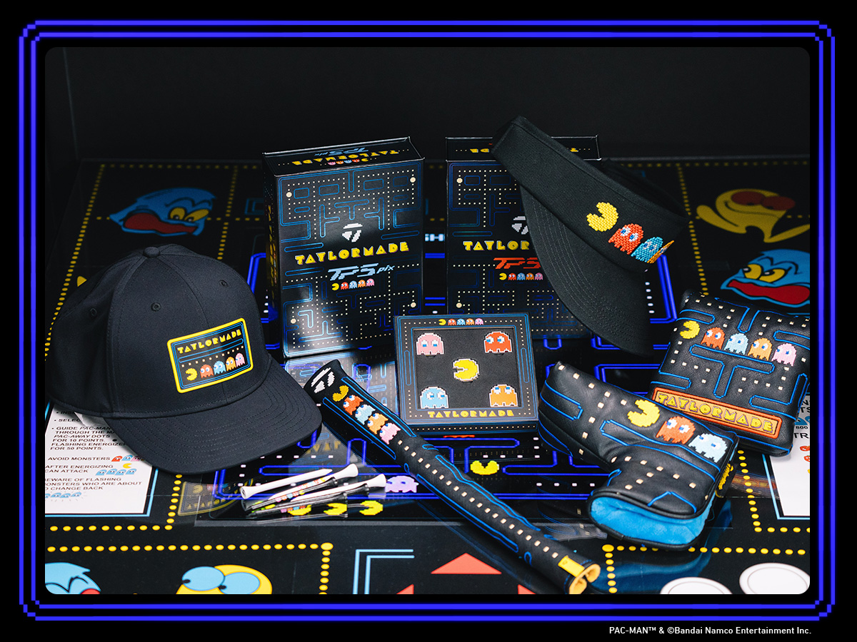 Full set of accessories in the TaylorMade | PacMan collaboration, laid out on a PacMan themed table, including the hat, visor, alignment stick, two putter headcovers, balls, tees and ball marker box