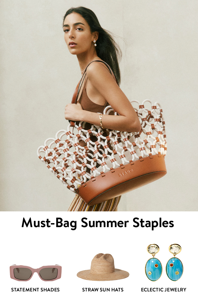 A woman wearing an oversized tote bag. Rectangular sunglasses, straw sun hat, patterned drop earrings.